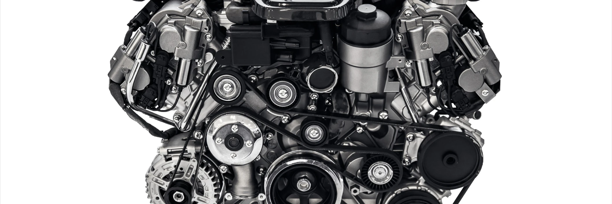 Close-up of a complex car engine against a white background. The image shows intricate mechanical parts, pulleys, and belts, highlighting engineering detail.
