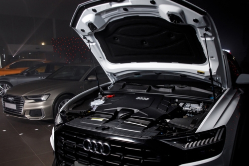 Open hood of an Audi vehicle undergoing diagnostics and electrical repair at MB Automotive Services