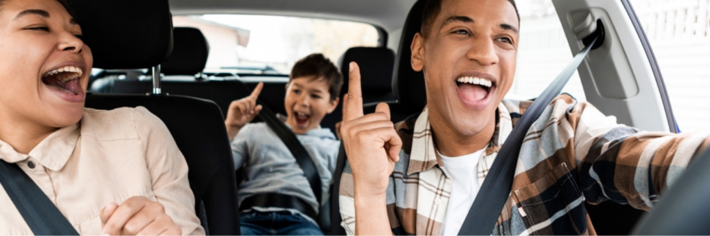BMW road trip readiness by MB Automotive Services in Rockville, MD: Excited young African American family singing in their car, highlighting the importance of pre-trip checks for a safe and enjoyable summer road trip.