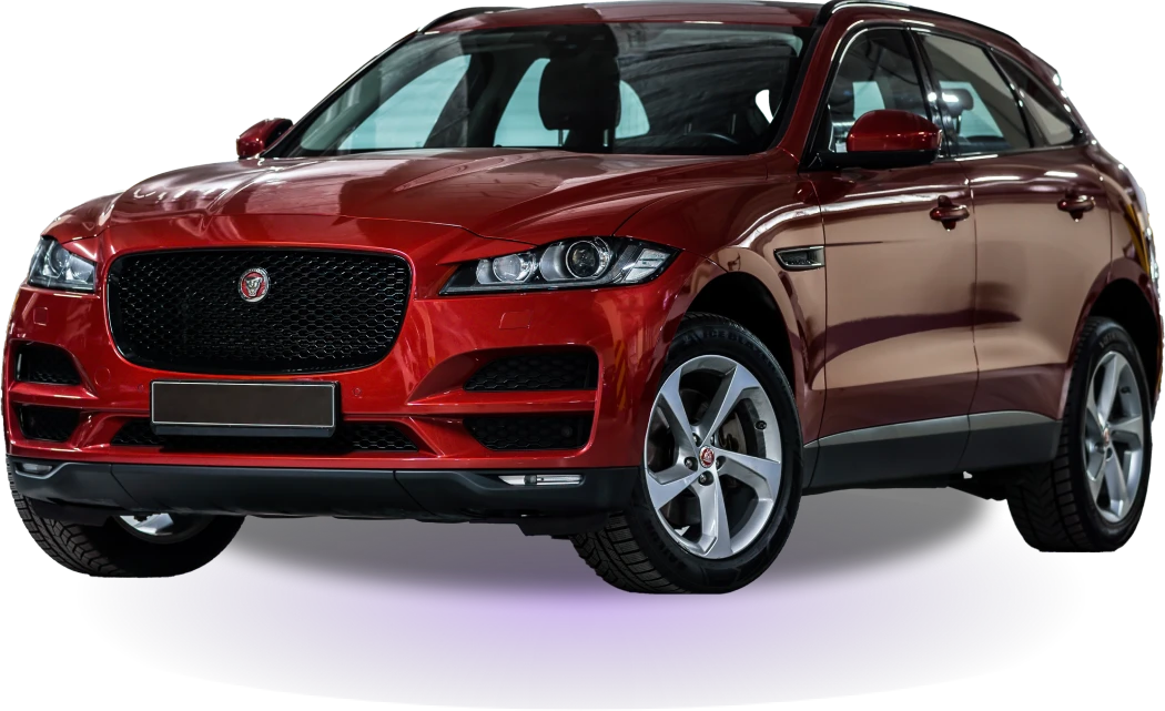 A sleek, shiny red SUV with a prominent front grille and silver alloy wheels is displayed against a black background, conveying luxury and power.