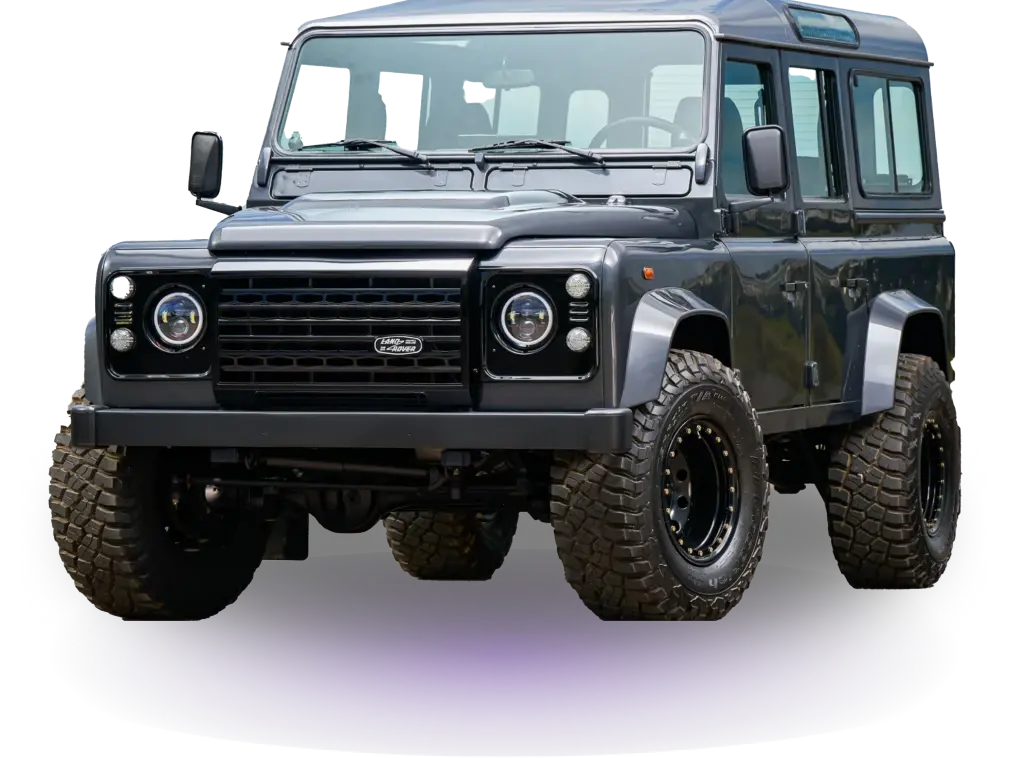 Dark gray off-road vehicle with rugged tires, seen from the front against a black background. The car conveys strength and adventure.