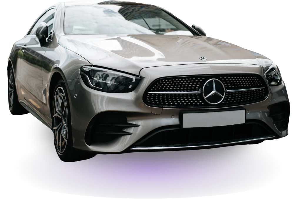 Sleek silver luxury sedan with a prominent front grille and logo, set against a dark background. The car exudes elegance and modern design.